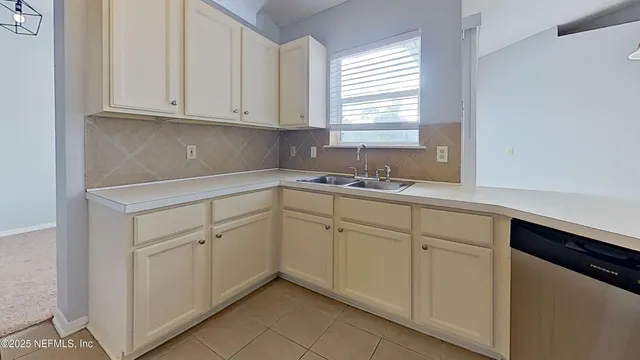 a kitchen with white cabinets white appliances and a sink
