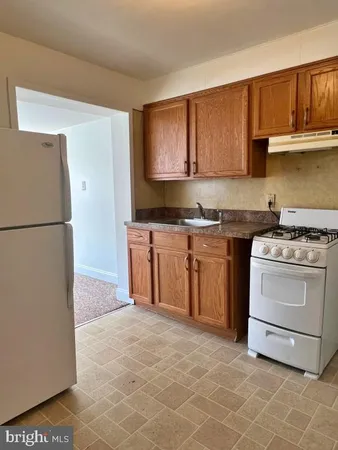 a kitchen with a stove sink and a refrigerator