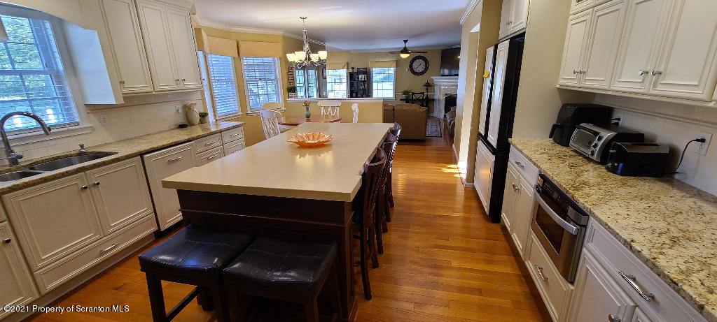 129 Bald Mountain Road Wilkes Barre, PA 18702 - Photo 11 of 40 a kitchen with stainless steel appliances granite countertop a refrigerator a sink dishwasher a stove and white cabinets with wooden floor