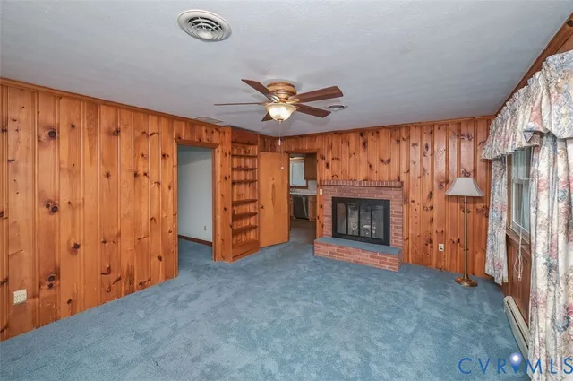 a view of an empty room with a fireplace and a window