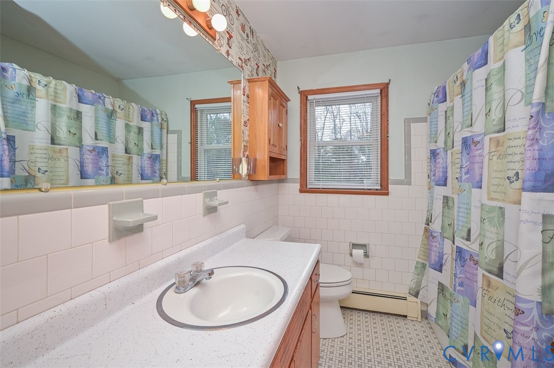 1629 New Market Road Henrico, VA 23231 - Photo 31 of 49 a bathroom with a sink a mirror a toilet and a shower