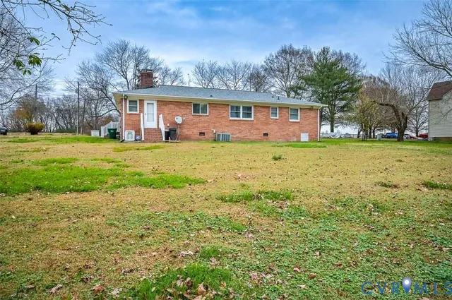 a view of a house with a big yard and large trees