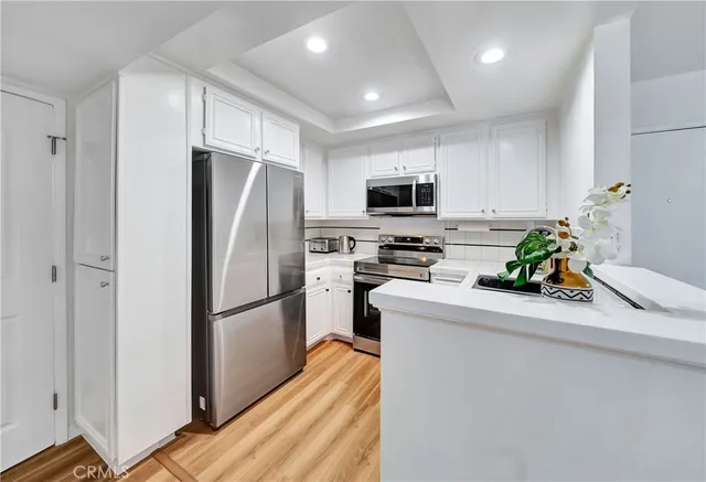 a kitchen with stainless steel appliances a refrigerator a sink a stove a microwave a refrigerator and cabinets