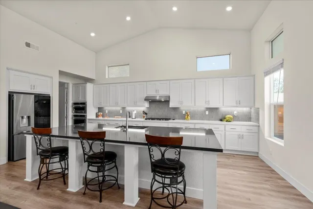 a large kitchen with stainless steel appliances lots of counter space and wooden floor