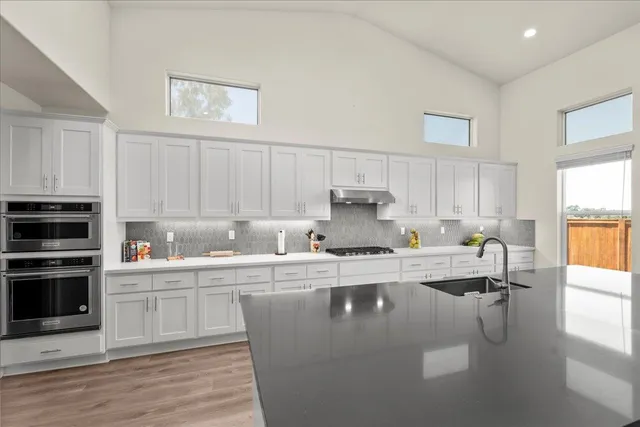 a kitchen with granite countertop a sink and cabinets