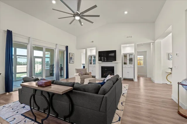 a living room with furniture a flat screen tv and kitchen view