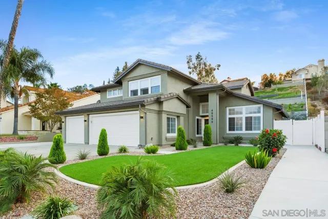 a front view of a house with a garden and plants