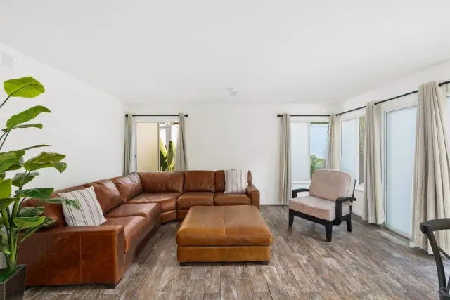 a living room with furniture and a dining table with kitchen view