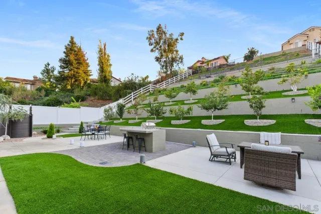 a view of a patio with table and chairs potted plants with wooden fence