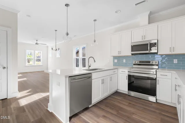 a kitchen with stainless steel appliances granite countertop a stove a sink and a microwave