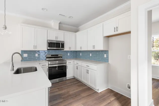 a kitchen with granite countertop white cabinets and stainless steel appliances