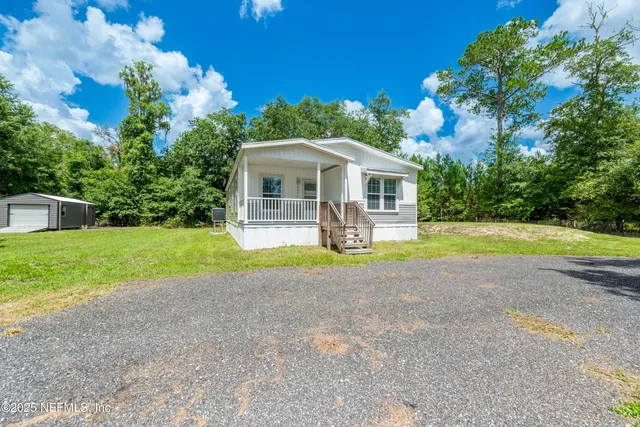 a view of a house with a backyard and a garden