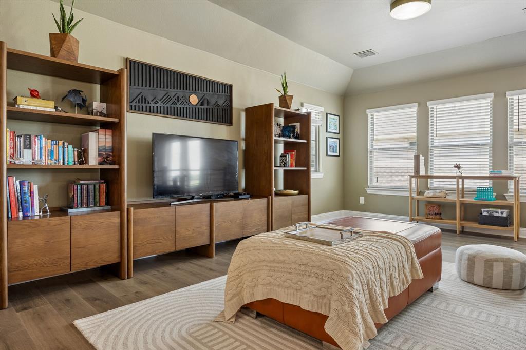 425 Breeds Hl Road Little Elm, TX 75068 - Photo 19 of 38 a bedroom with a bed and a flat screen tv