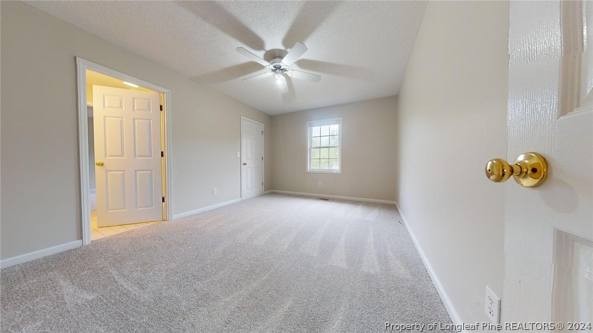 1340 Roseland Road Aberdeen, NC 28315 - Photo 25 of 39 a view of an empty room with chandelier fan and fire place