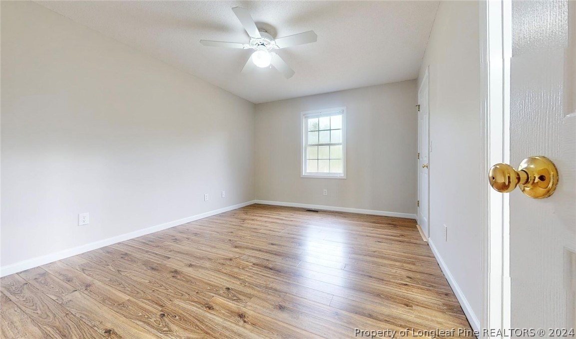 1340 Roseland Road Aberdeen, NC 28315 - Photo 27 of 39 an empty room with wooden floor and windows