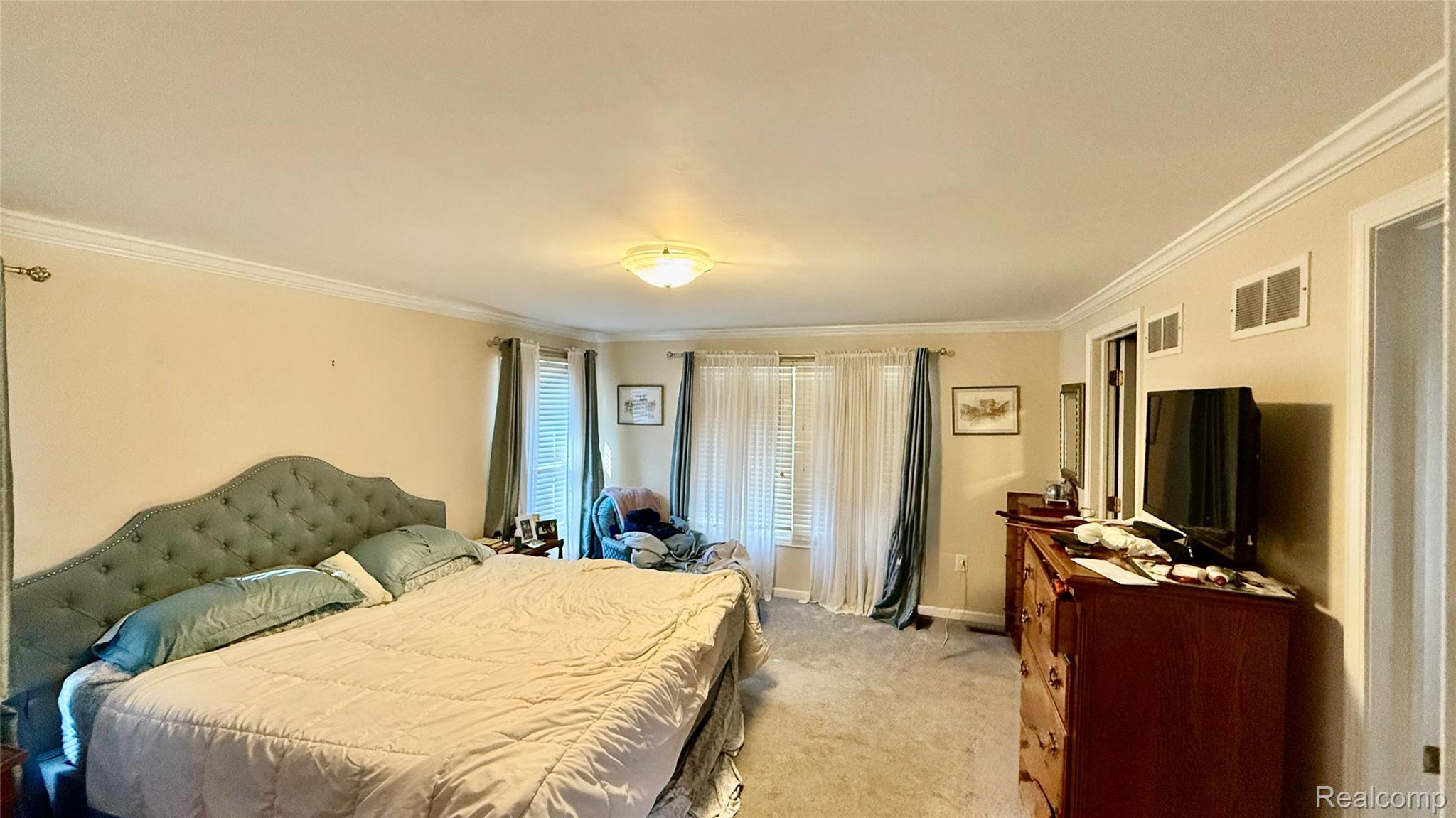 889 Rivard Boulevard Grosse Pointe, MI 48230 - Photo 15 of 18 Spacious carpeted room featuring crown molding, neutral wall color, multiple windows with blinds, and a ceiling-mounted light fixture