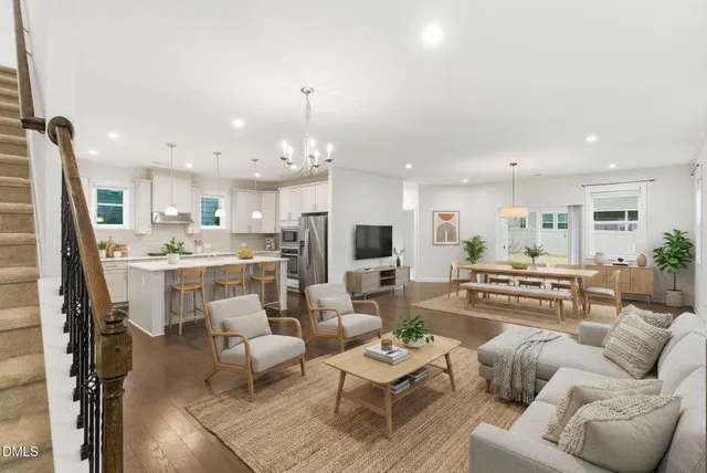 a living room with furniture kitchen view and a chandelier