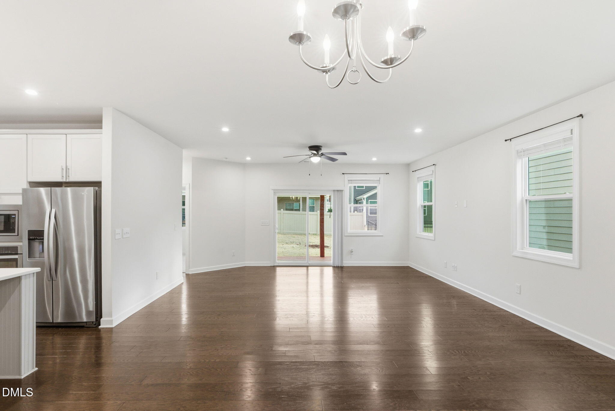 2913 Macbeth Lane Apex, NC 27502 - Photo 13 of 62 a view of an empty room with wooden floor and a kitchen