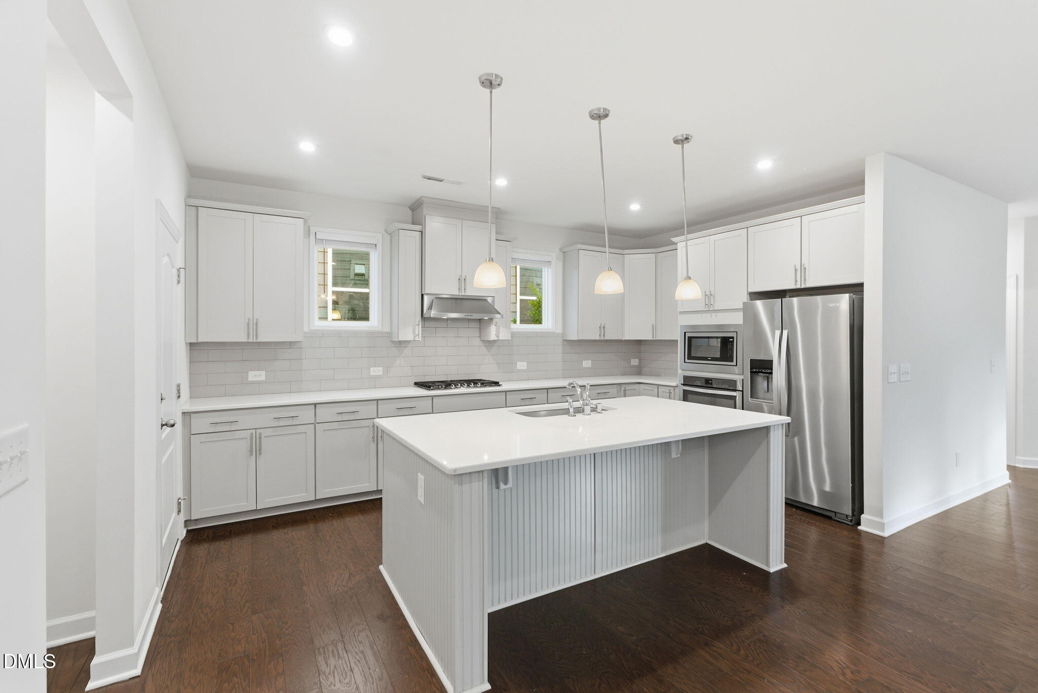 2913 Macbeth Lane Apex, NC 27502 - Photo 15 of 62 a kitchen with a sink a center island stainless steel appliances and cabinets
