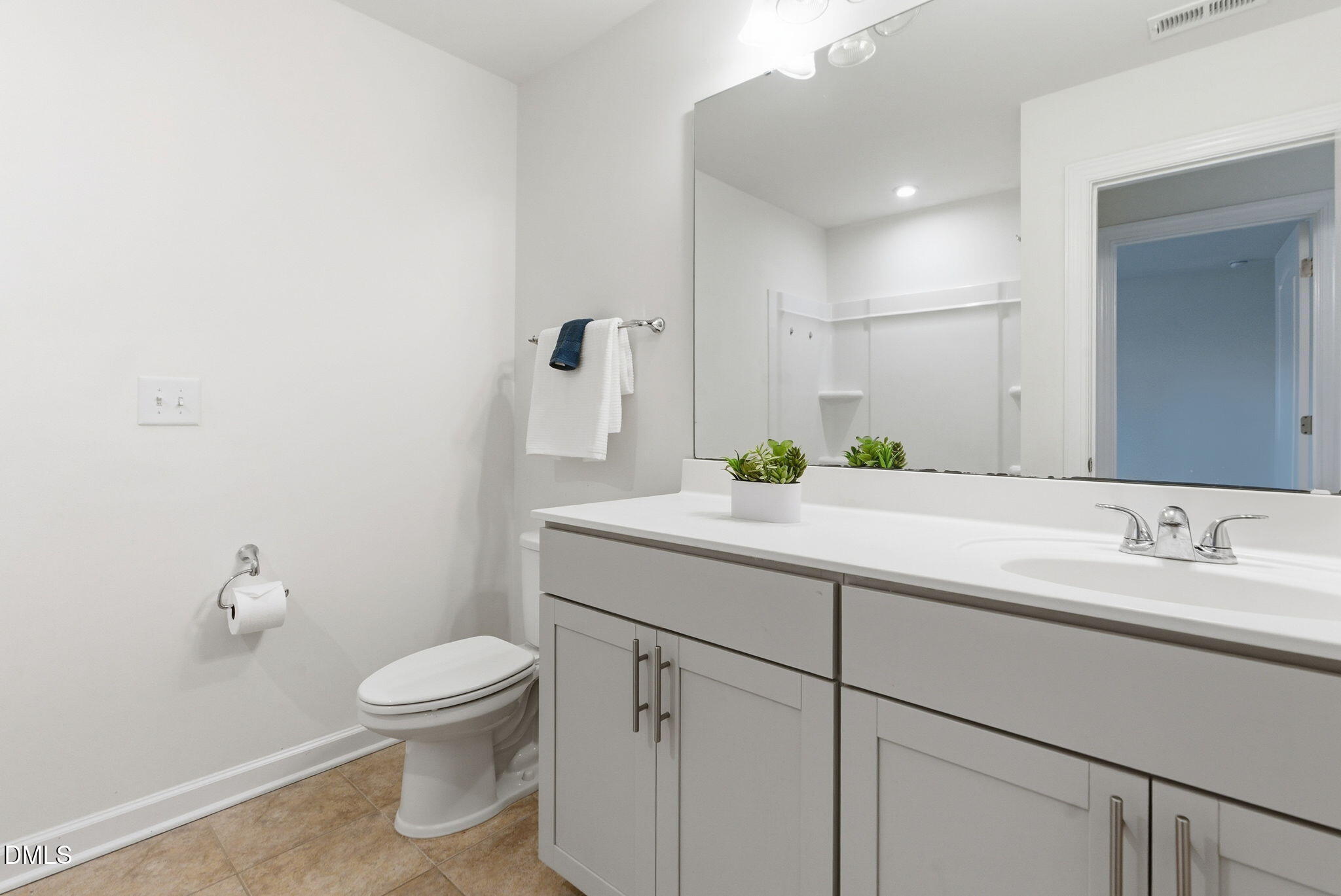 2913 Macbeth Lane Apex, NC 27502 - Photo 35 of 62 a bathroom with a granite countertop sink a toilet and a mirror