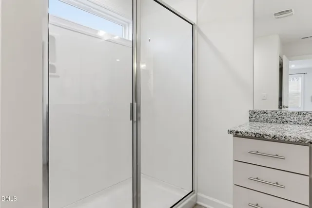 a view of a white house with a yard and wooden fence