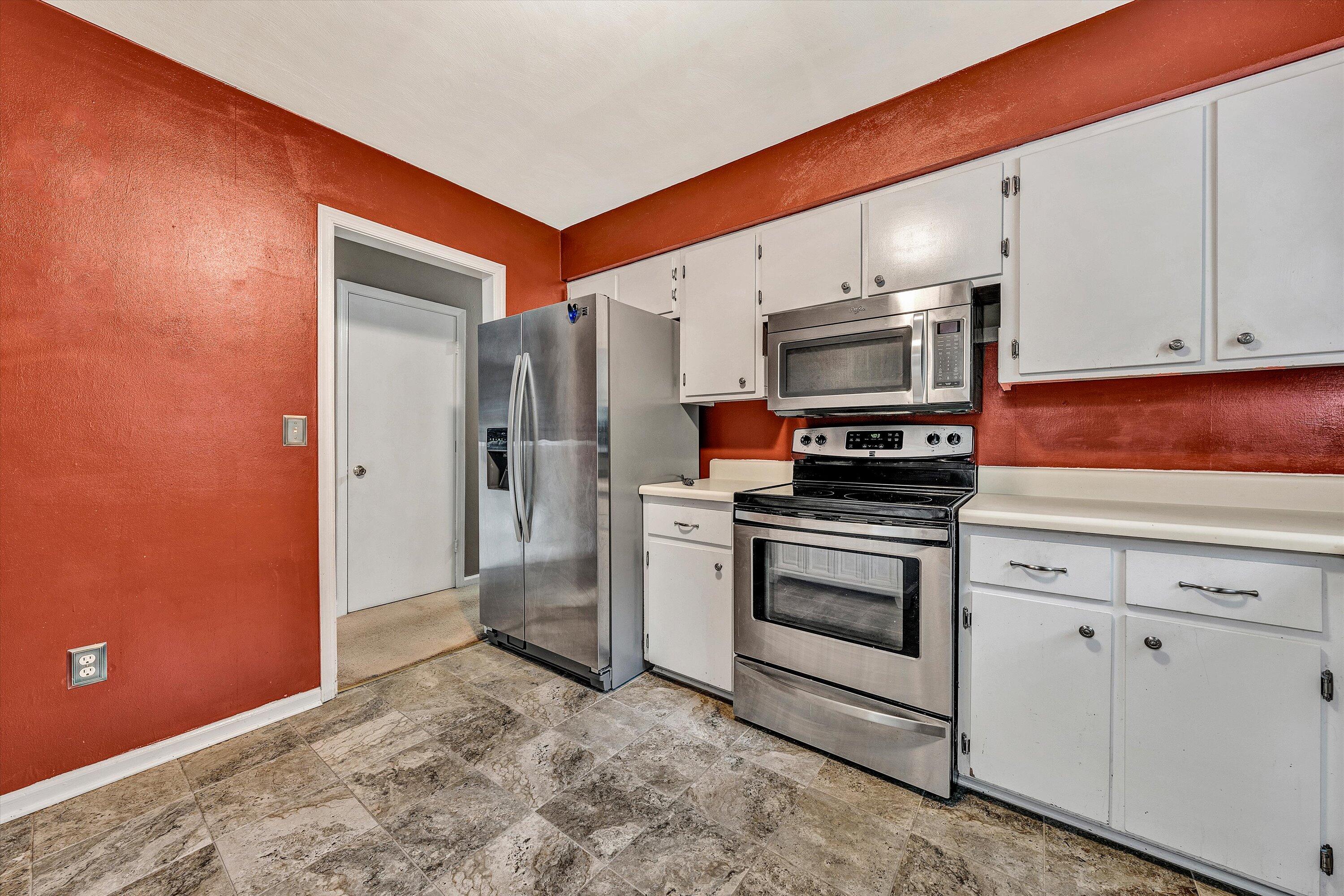 709 Ramada Road Vinton, VA 24179 - Photo 9 of 32 a kitchen with stainless steel appliances a stove a microwave and white cabinets