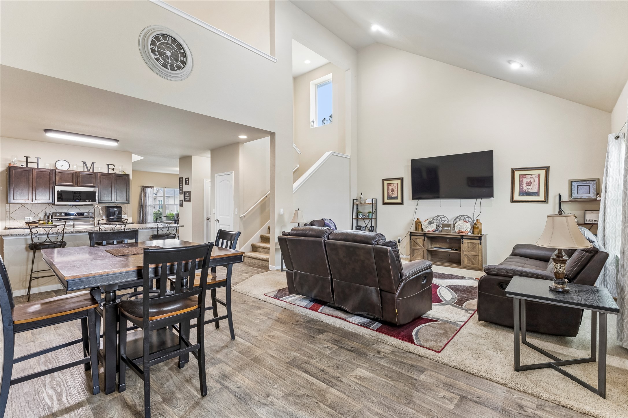 14409 Estuary Road Manor, TX 78653 - Photo 7 of 24 Vaulted ceilings accent an open-concept living area with wood-finish flooring