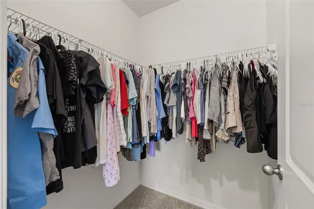 a view of walk in closet with clothes