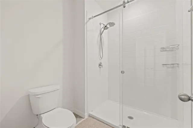 a white toilet next to a bathroom