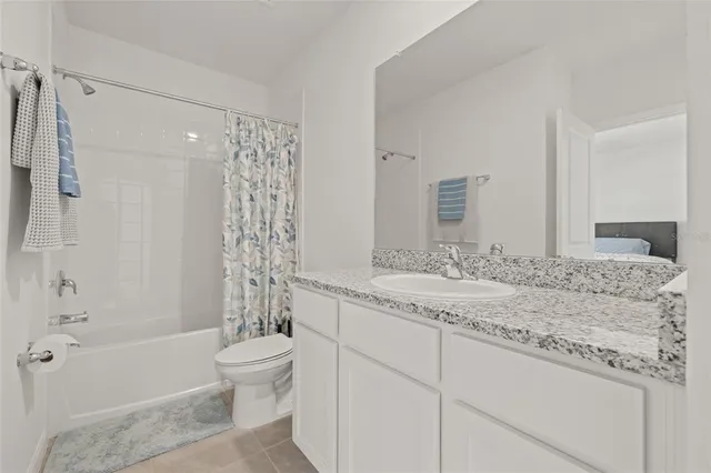 a bathroom with a granite countertop sink a toilet and shower
