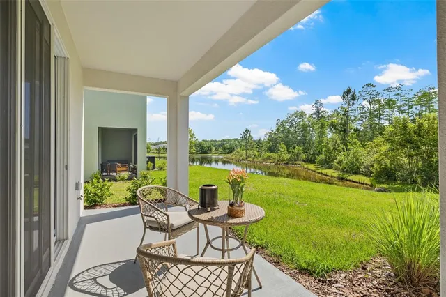 a patio with table and chairs and potted plants