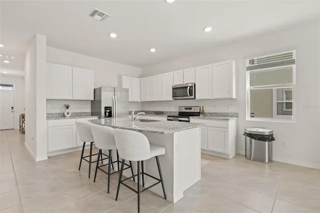 a kitchen with cabinets stainless steel appliances and a window