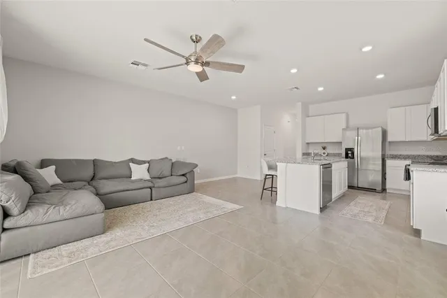 a living room with furniture and kitchen view
