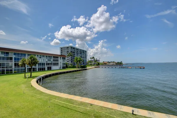 a bedroom with a bed a chair and a large window