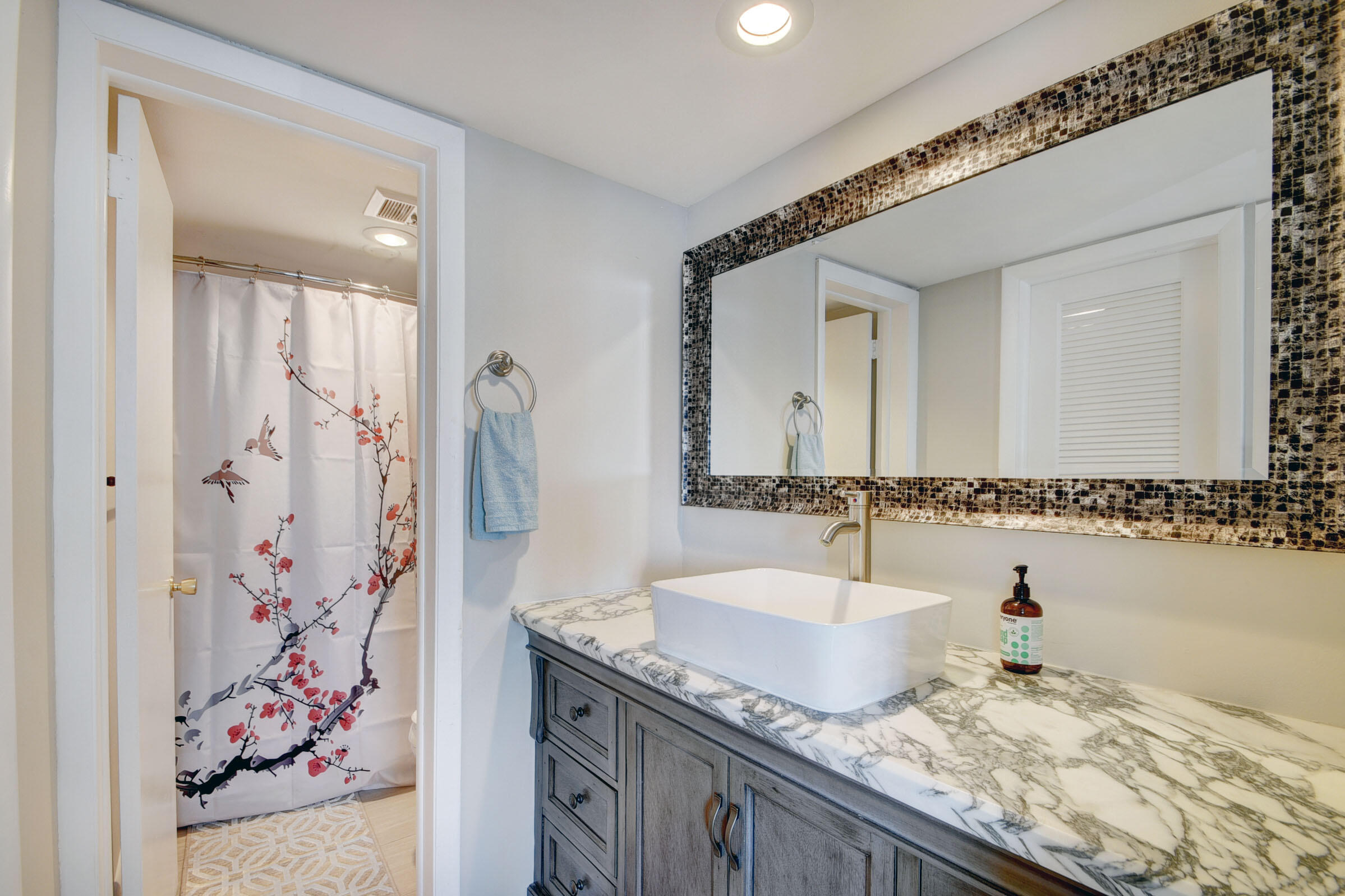 410 Wilma Circle, Unit 204 Riviera Beach, FL 33404 - Photo 18 of 25 a bathroom with a granite countertop sink and a mirror