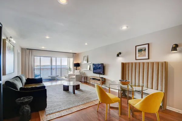a living room with furniture a wooden floor and a potted plant