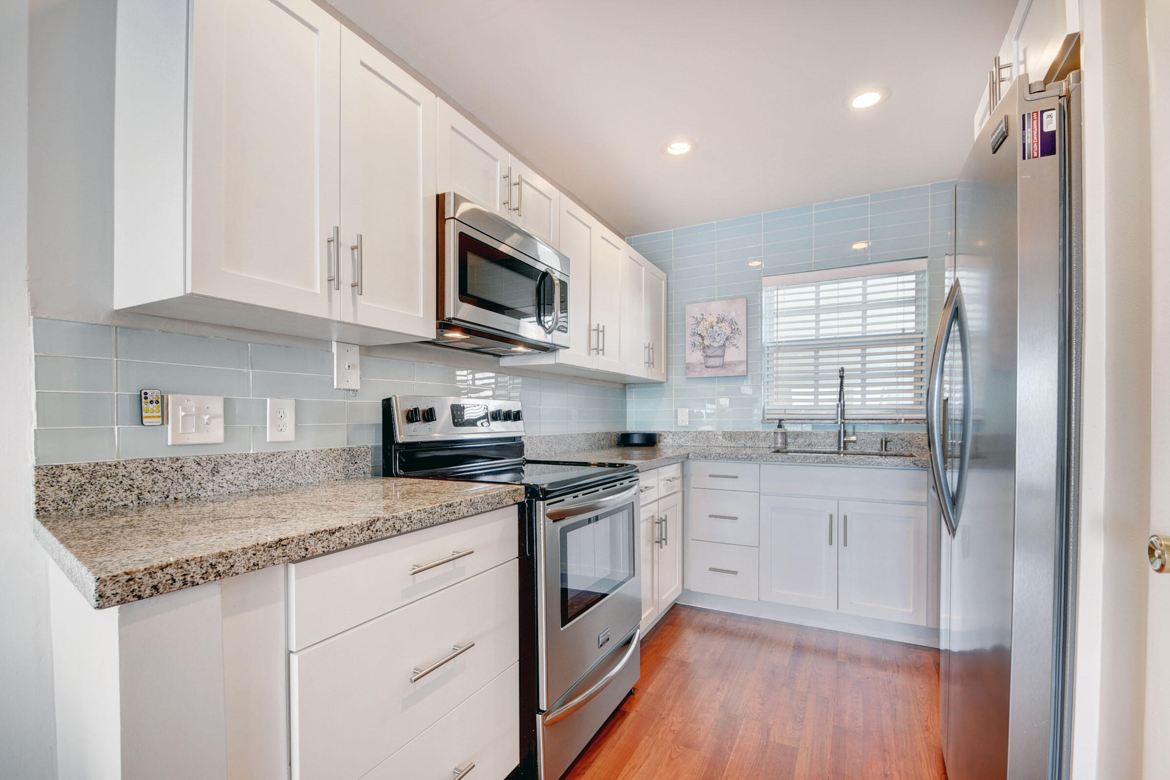 410 Wilma Circle, Unit 204 Riviera Beach, FL 33404 - Photo 6 of 25 a kitchen with stainless steel appliances granite countertop a sink stove and microwave