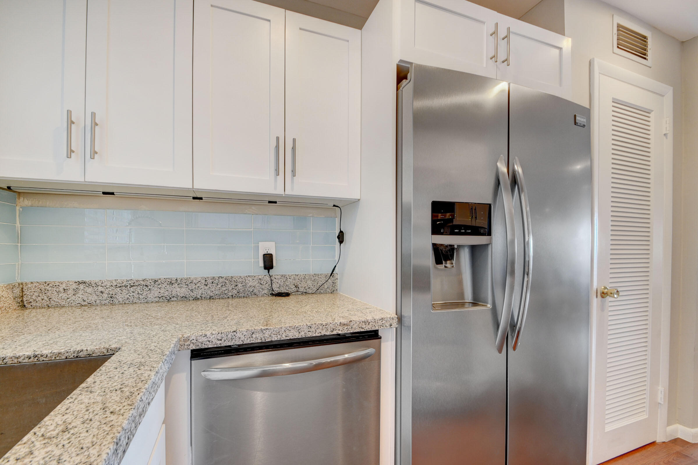 410 Wilma Circle, Unit 204 Riviera Beach, FL 33404 - Photo 7 of 25 a kitchen with granite countertop a refrigerator and cabinets