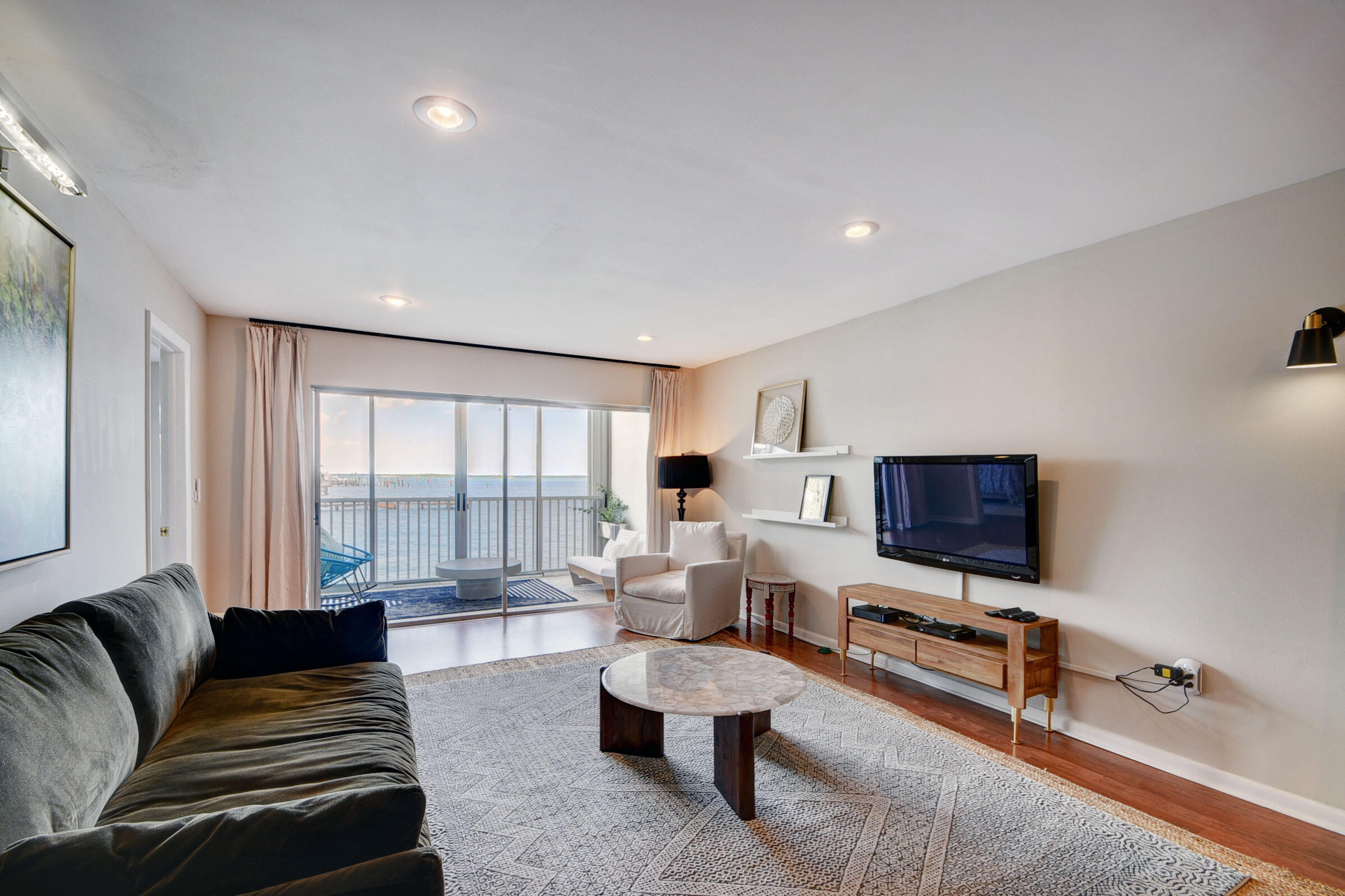 410 Wilma Circle, Unit 204 Riviera Beach, FL 33404 - Photo 8 of 25 a living room with furniture and a flat screen tv
