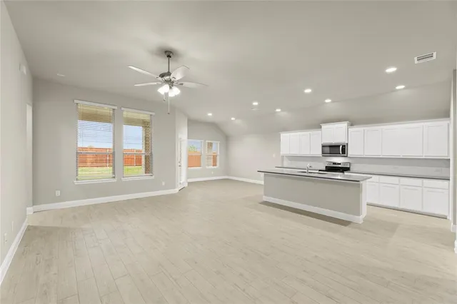 wooden floor in an empty room with a ceiling fan