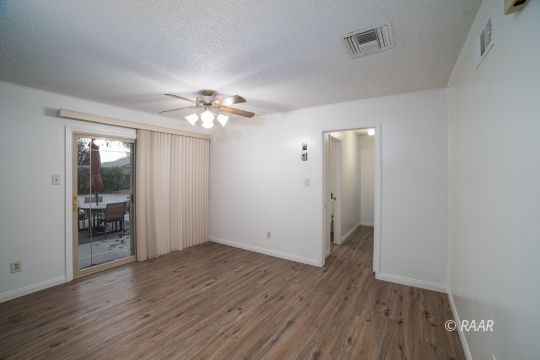 315 East Robertson Road Ridgecrest, CA 93555 - Photo 26 of 27 an empty room with wooden floor and a ceiling fan