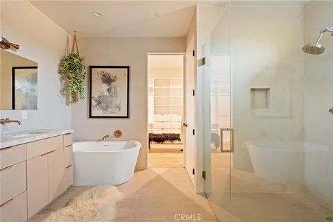 a bathroom with a white tub a vanity a sink and a shower