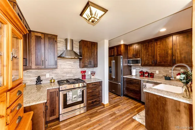 a kitchen with stainless steel appliances granite countertop a stove refrigerator sink and cabinets