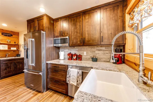 a kitchen with stainless steel appliances granite countertop a refrigerator and a sink