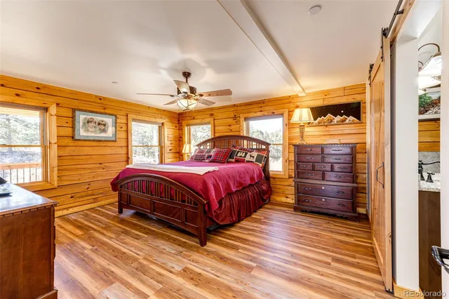 a spacious bedroom with a bed and wooden floor