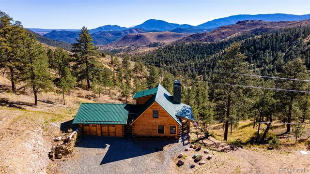 a front view of a house with a yard and a large tree