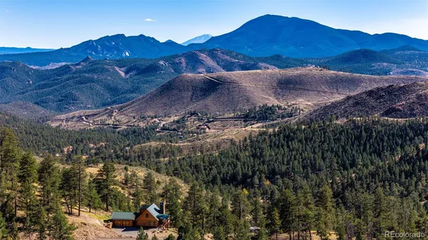 a view of a house with a mountain and a forest