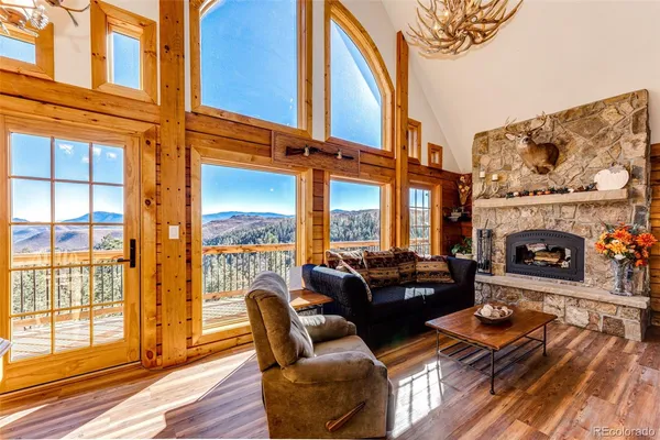a living room with furniture a fireplace and a floor to ceiling window