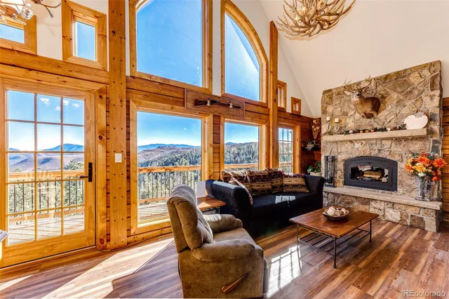a living room with furniture a fireplace and a floor to ceiling window