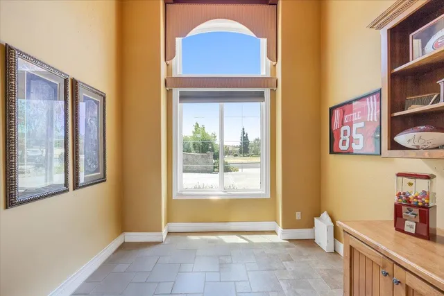 a room with lots of tables a large window and chairs